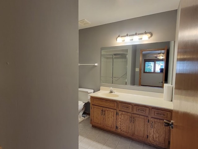 bathroom with toilet, vanity, and tile patterned flooring