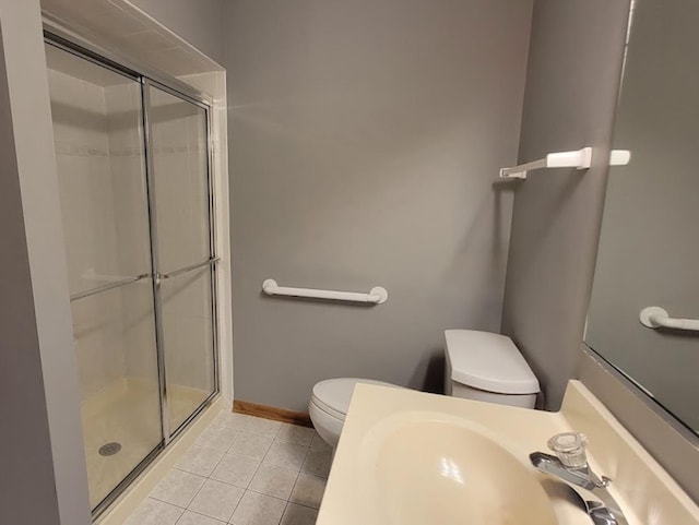 bathroom with toilet, tile patterned flooring, a shower with door, and sink