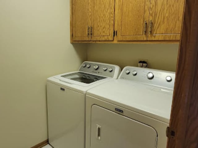 washroom featuring cabinets and washer and dryer