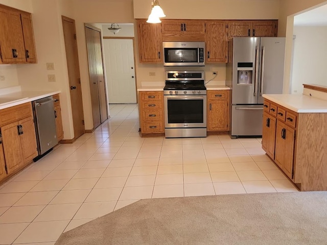 kitchen featuring light tile patterned floors, appliances with stainless steel finishes, sink, and pendant lighting