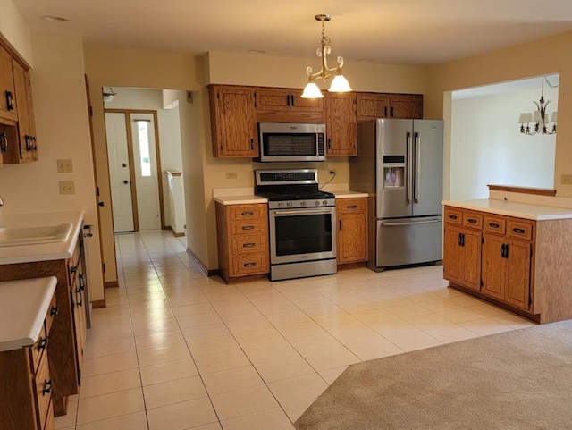 kitchen with decorative light fixtures, sink, an inviting chandelier, and stainless steel appliances