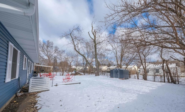 yard layered in snow with a storage shed