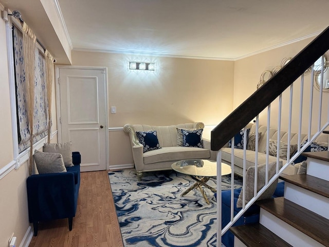 living room with baseboards, stairs, ornamental molding, and wood finished floors