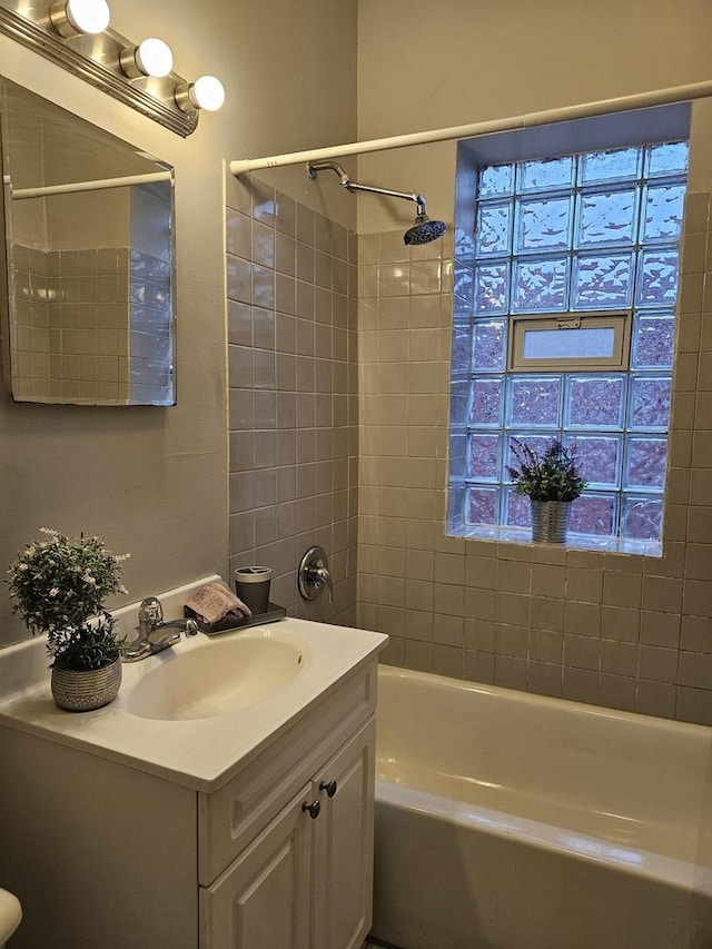 bathroom with tiled shower / bath combo and vanity