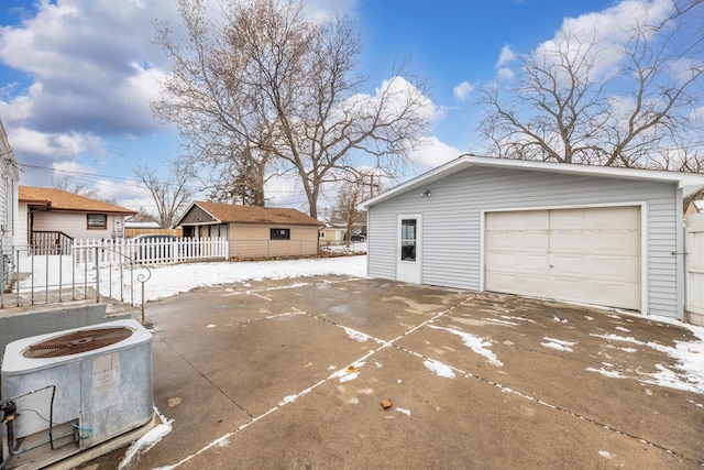 snow covered garage featuring cooling unit