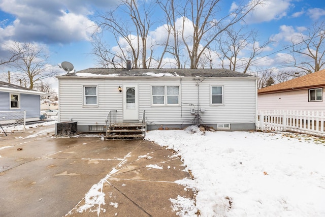 snow covered rear of property with central AC