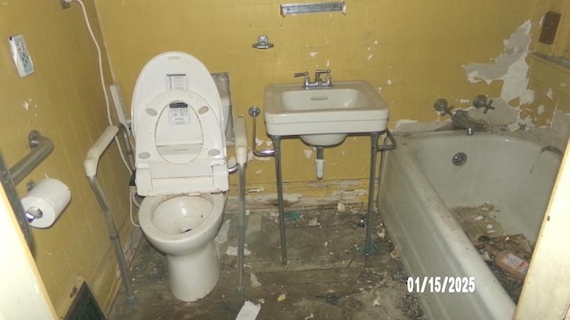 bathroom with toilet, sink, tile walls, and a bathing tub