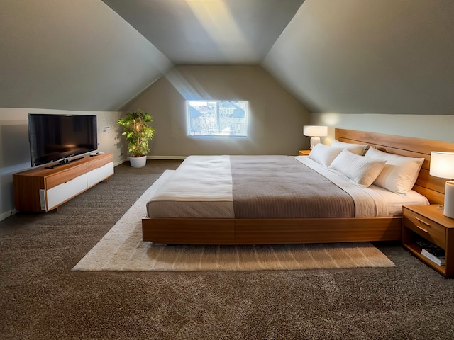 bedroom with dark colored carpet and lofted ceiling