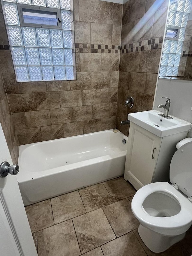 full bathroom featuring toilet, tiled shower / bath, and vanity