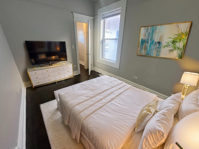 bedroom with dark hardwood / wood-style floors