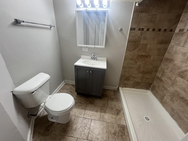 bathroom featuring a shower, toilet, and vanity