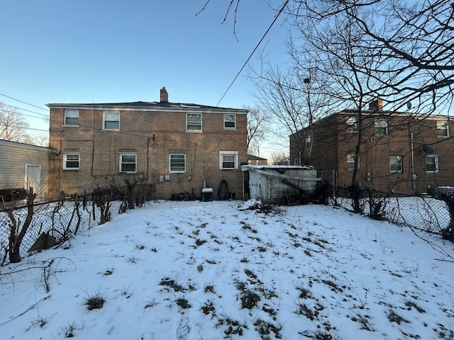 snow covered back of property with central AC unit