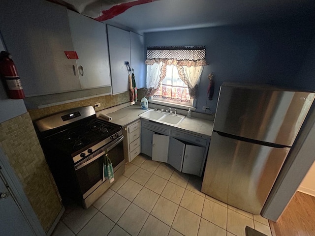 kitchen featuring light tile patterned floors, sink, and appliances with stainless steel finishes