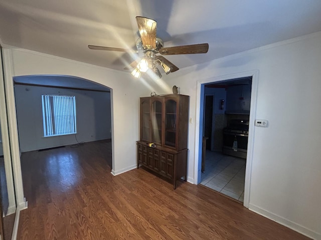 empty room with ceiling fan, dark hardwood / wood-style floors, and ornamental molding