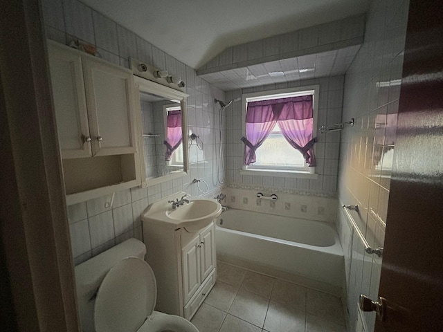 bathroom with tile patterned floors, vanity, tile walls, toilet, and vaulted ceiling