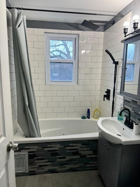 bathroom with shower / tub combo and vanity