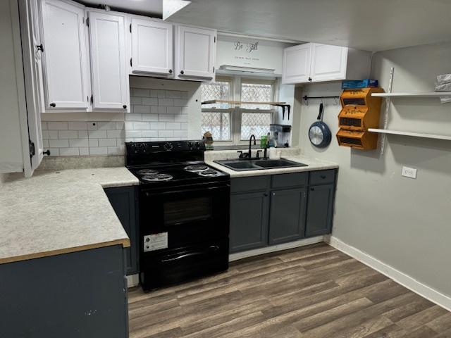 kitchen featuring white cabinets, dark hardwood / wood-style flooring, tasteful backsplash, sink, and electric range