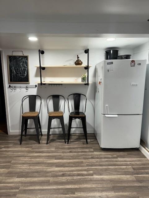 kitchen with white fridge and hardwood / wood-style flooring