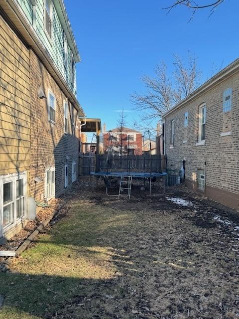 view of yard featuring a trampoline and central air condition unit