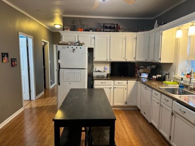 kitchen with white cabinetry, crown molding, hardwood / wood-style floors, and white appliances