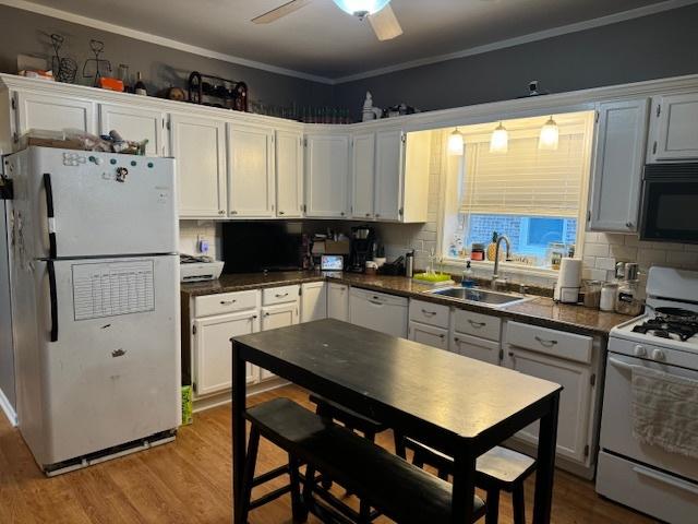 kitchen with white cabinetry, ceiling fan, white appliances, light wood-type flooring, and sink