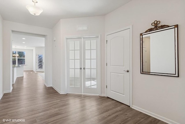 interior space with visible vents, baseboards, wood finished floors, and french doors