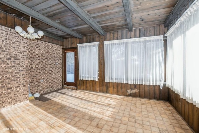 unfurnished sunroom featuring a notable chandelier, beam ceiling, and wooden ceiling