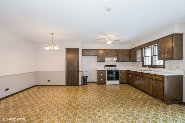 kitchen featuring ceiling fan with notable chandelier, decorative light fixtures, sink, white gas range oven, and dark brown cabinets