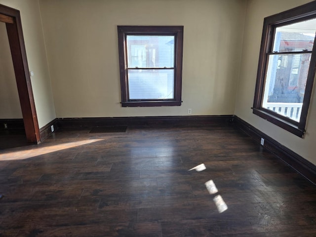 empty room with dark hardwood / wood-style flooring