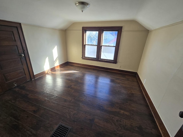 additional living space featuring vaulted ceiling and dark hardwood / wood-style flooring