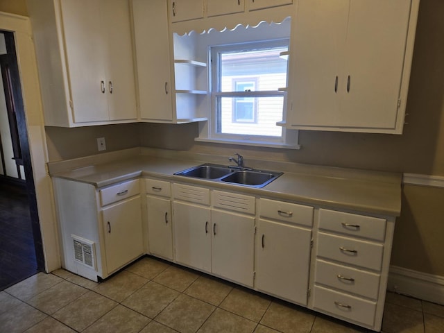 kitchen featuring sink, white cabinetry, and light tile patterned flooring