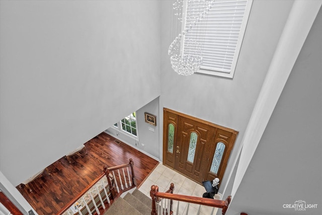 entrance foyer featuring a high ceiling, an inviting chandelier, and light tile patterned flooring