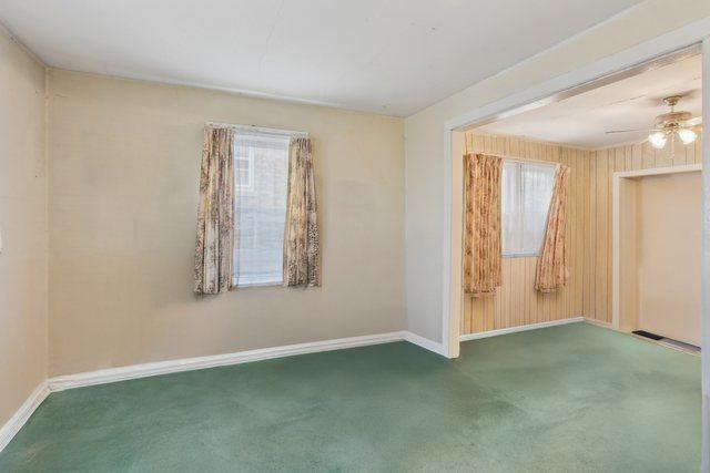 carpeted spare room with ceiling fan