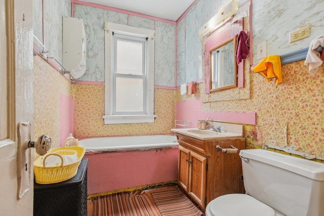 bathroom with vanity, a tub, and toilet