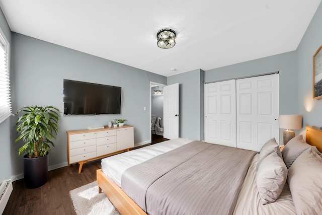 bedroom with a closet, dark hardwood / wood-style flooring, and a baseboard radiator