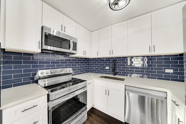 kitchen with appliances with stainless steel finishes, backsplash, white cabinets, and sink