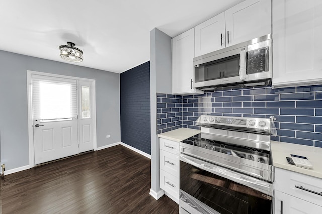 kitchen featuring dark hardwood / wood-style floors, stainless steel appliances, backsplash, and white cabinetry