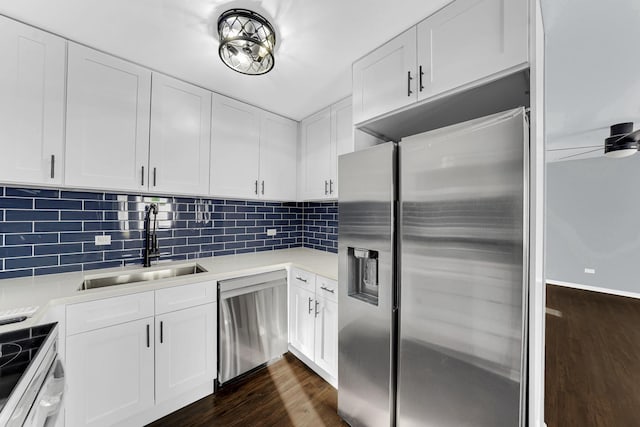 kitchen with white cabinetry, dark hardwood / wood-style flooring, stainless steel appliances, decorative backsplash, and sink