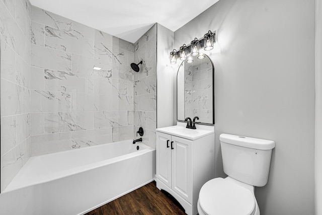 full bathroom with hardwood / wood-style floors, toilet, vanity, and tiled shower / bath