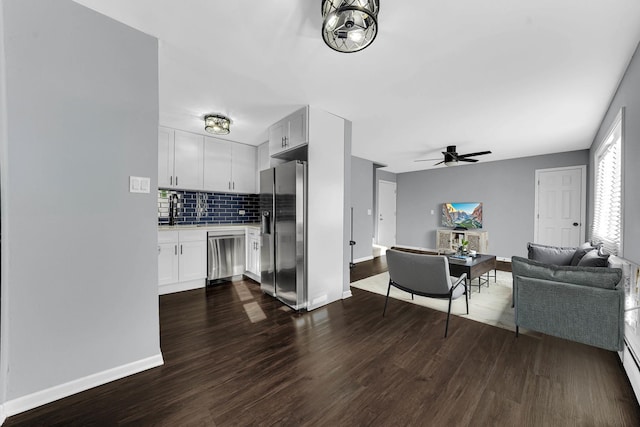 kitchen with backsplash, white cabinetry, dark hardwood / wood-style flooring, and stainless steel appliances