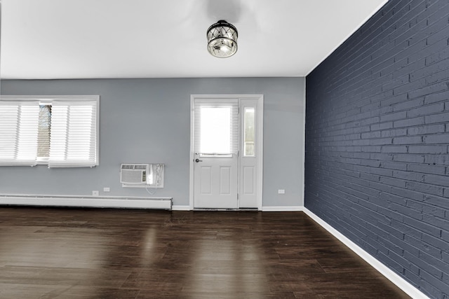 foyer featuring an AC wall unit, dark wood-type flooring, brick wall, and a baseboard heating unit