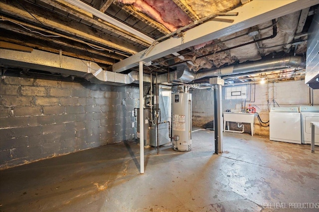 basement featuring washing machine and dryer, sink, and gas water heater