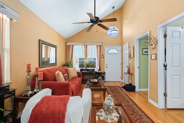 living room featuring vaulted ceiling, ceiling fan, and light wood-type flooring