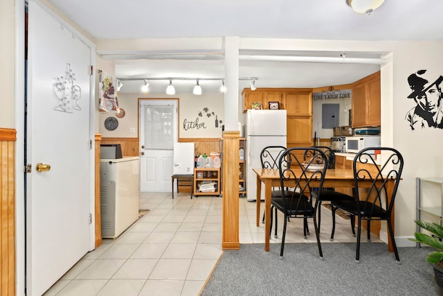 dining area with washer / dryer, light tile patterned floors, electric panel, and wood walls