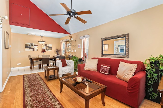 living room with ceiling fan, high vaulted ceiling, and light hardwood / wood-style flooring