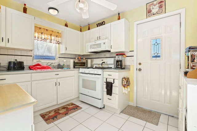 kitchen featuring white appliances, ceiling fan, white cabinetry, backsplash, and light tile patterned flooring