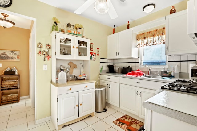 kitchen featuring white cabinetry, light tile patterned floors, and backsplash