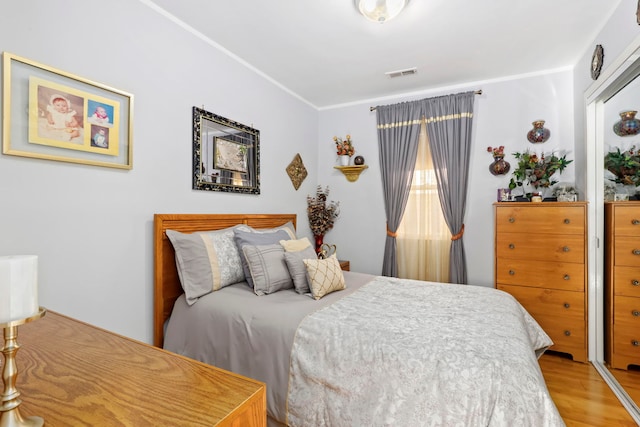 bedroom with wood-type flooring and ornamental molding