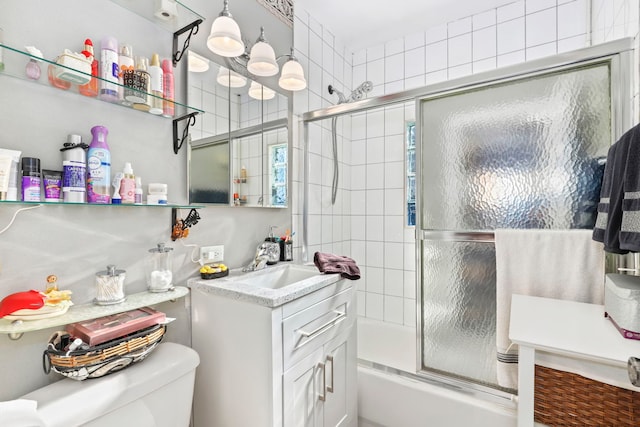 full bathroom with enclosed tub / shower combo, vanity, and toilet