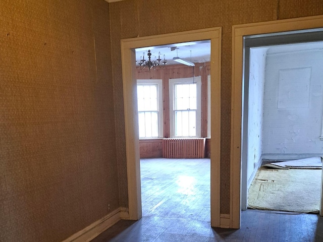 doorway to outside featuring a chandelier and wood finished floors